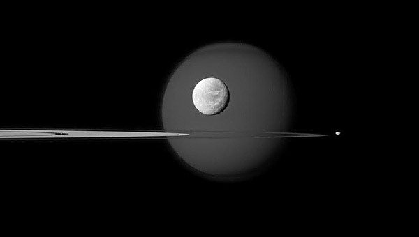 Dione na pozadí Titanu a Saturnovy prstence