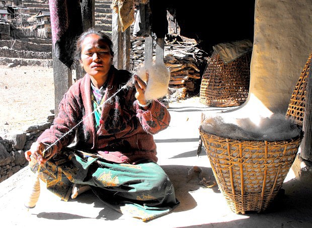 Nepálská žena motající vlnu. Poté se z vlny vyrábí tlusté teplé deky, které jsou rovněž těžké.